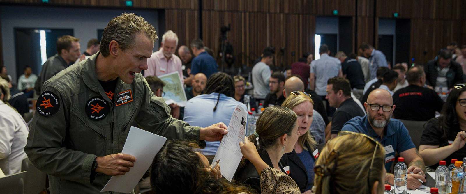 An Afterburner pilot working a mission table with delegates